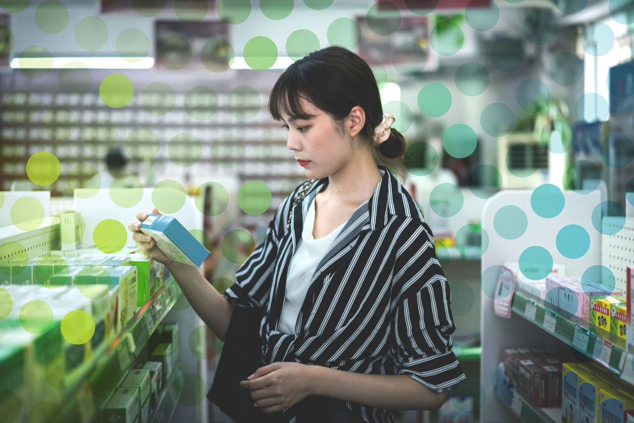 Woman in pharamacy checks label on box