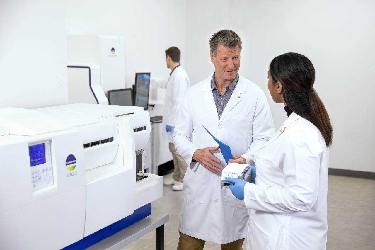 Two people working in lab talk together 