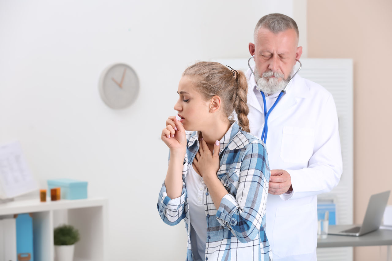 Female patient coughing at doctor's office