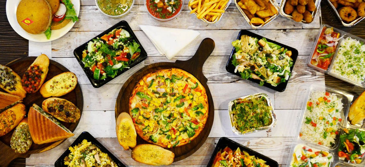 Spread of cooked foods on a wooden table