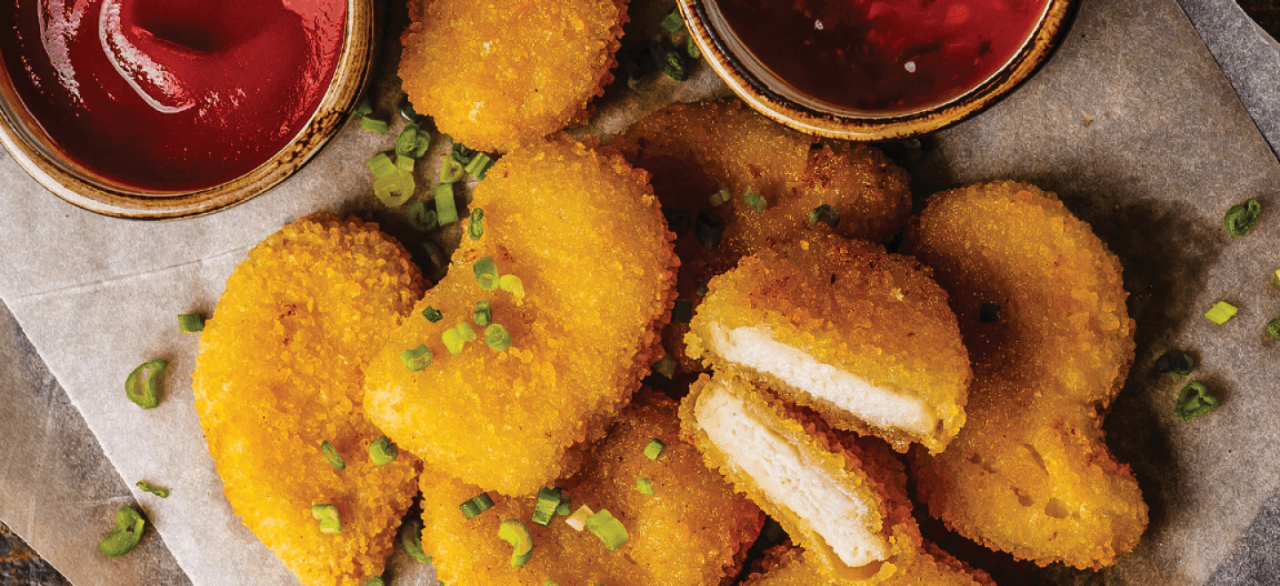 Pile of chicken nuggets next to ketchup